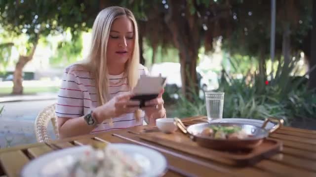 iJustine using the Duo half-open at an outdoor restaurant table